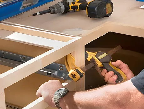 Skilled installer ensuring precision and level placement during a kitchen cabinet installation.