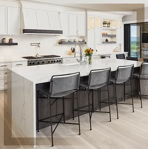 Luxurious white quartz waterfall island countertop with natural granite-style veining in a modern kitchen.